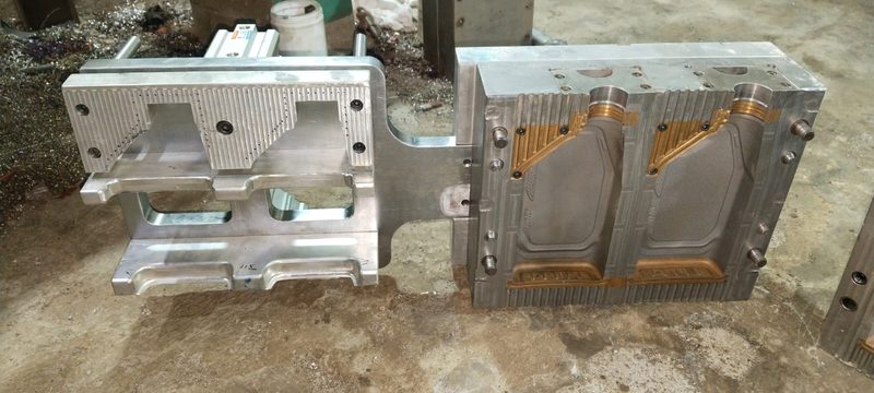 The same tooling family laid out on the floor — cavity block and core block, with the bronze Beryllium Copper inserts placed where heat has to leave the tool fastest.