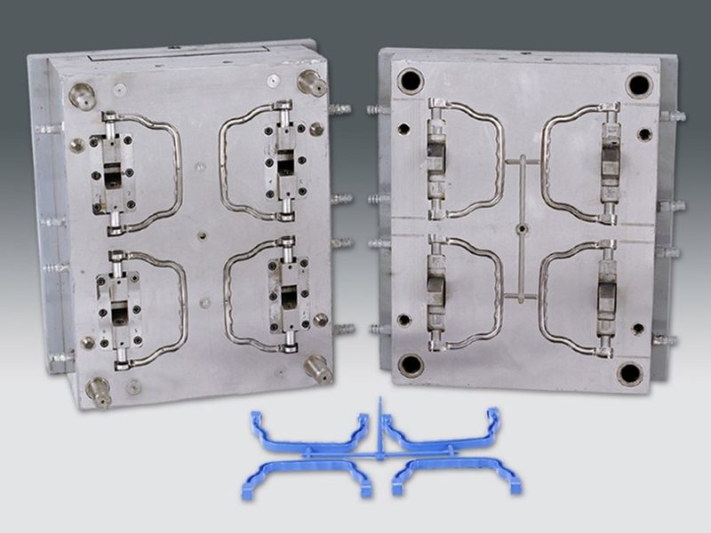 Four-cavity injection mould for a moulded carry handle, with the components still on the runner.